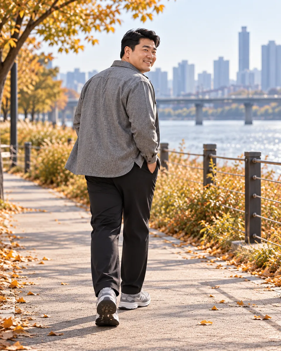 회색 셔츠 재킷을 입고 강변을 걷다가 돌아보는 큰 체격 남성 AI 모델 뒷모습